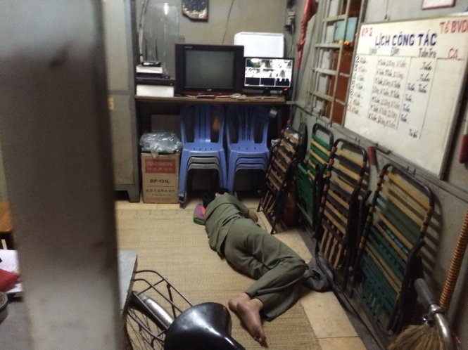 Một người trực nằm ngủ tại một chốt dân phòng ở Q.Gò Vấp - Ảnh: Lê Phan
