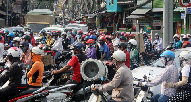 Hàng trăm phương tiện dồn ứ trên đường Nguyễn Phúc Nguyên nối ra vòng xoay Dân Chủ, phía xa xa là một xe cấp cứu bị kẹt trong đám đông kẹt xe - Ảnh: Q.Khải