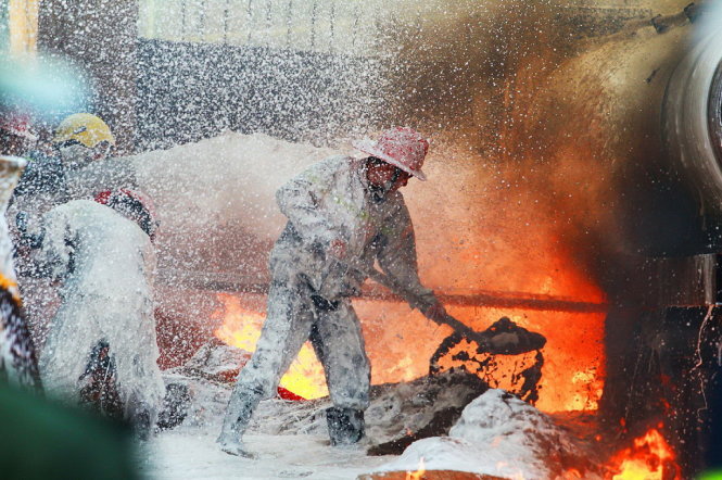Một chiến sĩ Cảnh sát PCCC đang khống chế đám cháy tại cây xăng 2B Trần Hưng Đạo vào ngày 3-6-2013 - Ảnh: Nguyễn Khánh
