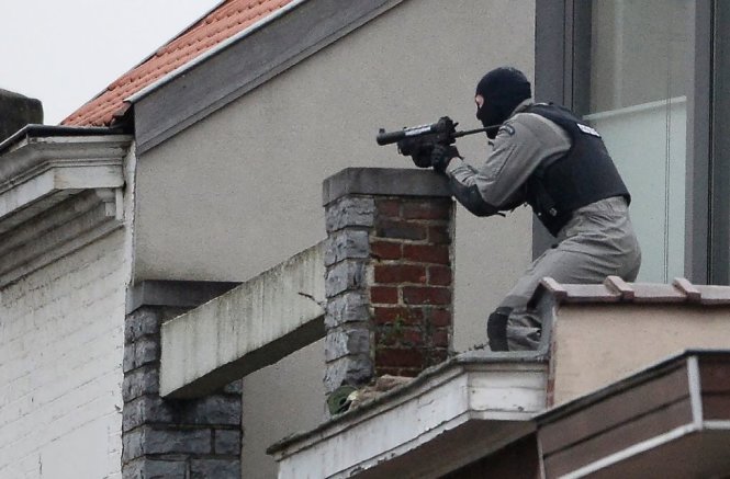 Một cảnh sát đặc nhiệm đang làm nhiệm vụ trên mái một ngôi nhà ở quận Forest, Brussels, Bỉ - Ảnh: AFP