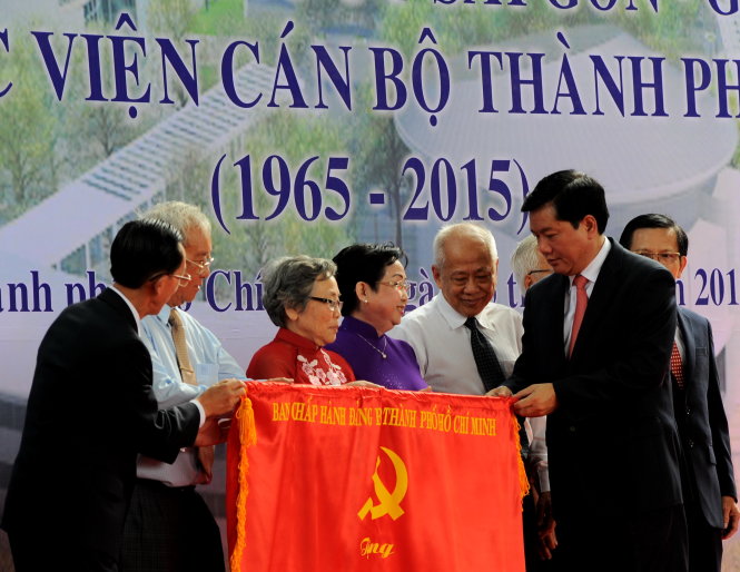 Ông Đinh La Thăng, bí thư Thành ủy TP.HCM, tặng cờ của Ban chấp hành Đảng bộ TP.HCM cho Học viện Cán bộ TP.HCM - Ảnh: Tự Trung
