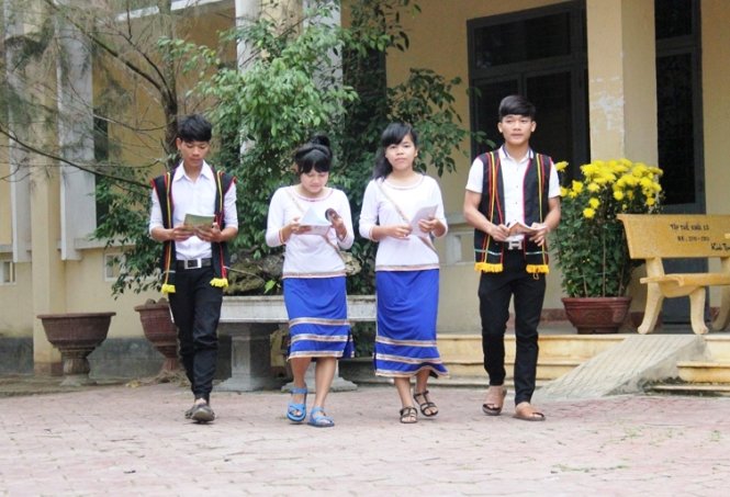 Các em học sinh đi học trong trang phục truyền thống của đồng bào người Cor - Ảnh: Trần Mai