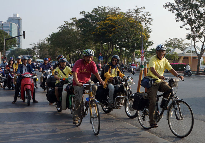 Anh Đào Kim Trang đạp xe đạp dẫn đầu, phía sau là các thành viên cùng đi và đồng đảo bạn bè tiển đưa một đoạn đường - Ảnh : N.C.T.