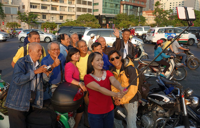 Nghệ sĩ đàn tranh Hải Phượng chụp ảnh “Selfie” cả nhóm trước lúc khởi hành tài đầu đường Nguyễn Huệ - Ảnh : Đắc Lộc