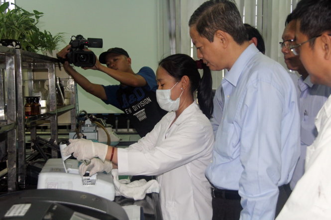 Ông Lê Văn Khoa - phó chủ tịch UBND TP, theo dõi nhân viên phòng thí nghiệm Nhà máy nước Tân Hiệp kiểm tra độ mặn trong nước - Ảnh: Q.Khải