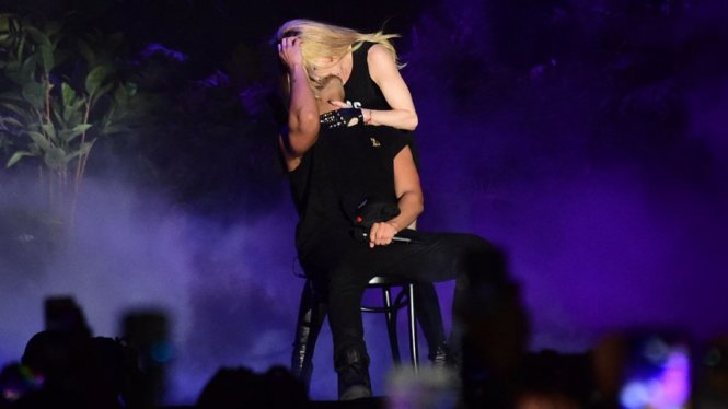 Chàng ca sĩ trẻ Drake chống chọi yếu ớt trước màn cưỡng hôn của đàn chị trong chính liveshow của anh - Ảnh: Hollywood Reporter