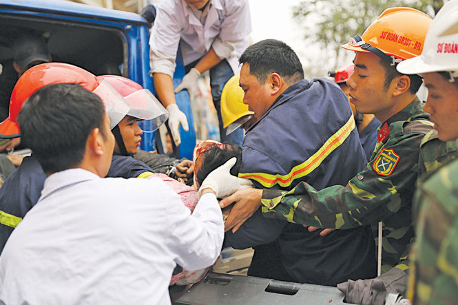 Các lực lượng cứu hộ khẩn trương đưa người bị nạn ra khỏi hiện trường đi cấp cứu - Ảnh: Trần Ngọc Kha