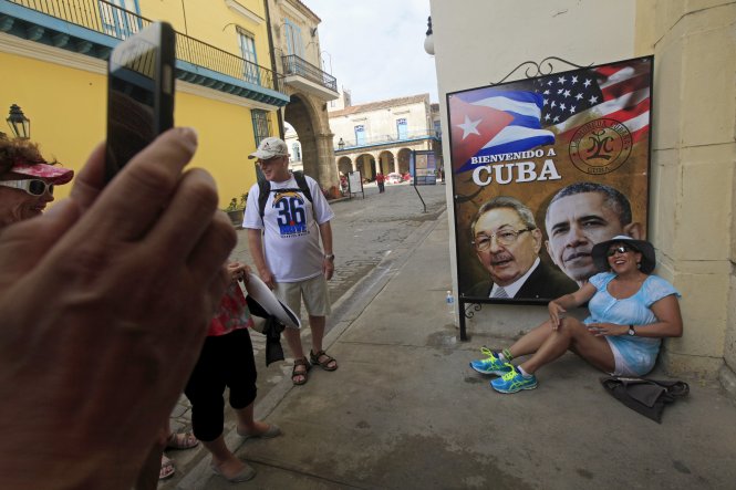 Du khách Mỹ chụp ảnh bên tấm biển chào mừng ông Obama ở Havana ngày 19-3 - Ảnh: Reuters