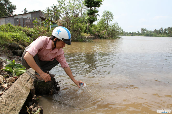 Cán bộ Phòng Nông nghiệp và phát triển nông thôn huyện Chợ Lách, tỉnh Bến Tre lấy mẫu nước tại xã Phú Sơn để đo độ mặn - Ảnh: Vân Trường