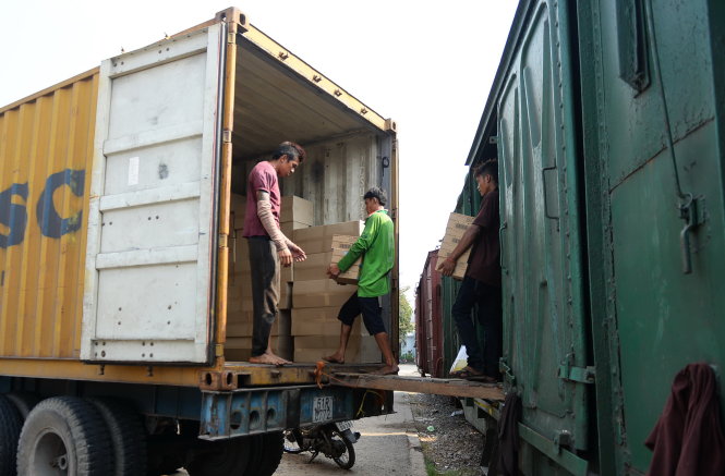 Nhiều chủ hàng phải chấp nhận tốn kém hơn, chuyển hàng hóa từ xe lửa tại ga Sóng Thần sang thuê xe container vận chuyển ra Hà Nội - Ảnh: Hữu Khoa