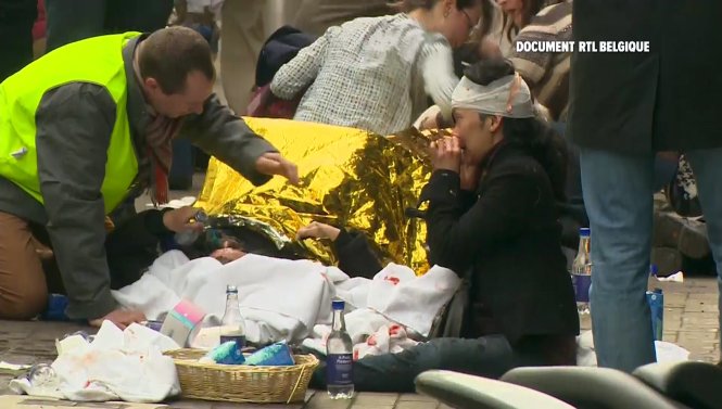 Lực lượng cứu hộ chăm sóc người bị thương trong vụ tấn công nhà ga tàu điện ngầm ở Brussels - Ảnh: Reuters