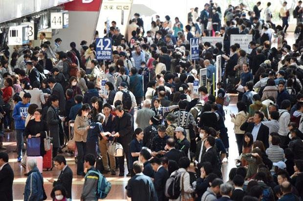 Các du khách xếp hàng dài chờ đặt vé mới tại sân bay Haneda Ảnh: AFP