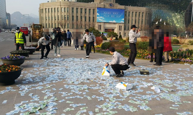 Tiền rải ở quảng trường Seoul chiều ngày 21-3 - Ảnh: The Korea Herald