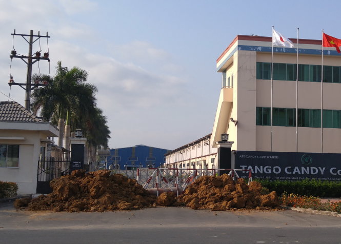 Cổng trước của Công ty TNHH Tango Candy bị đổ đất, dựng rào chắn từ ngày 18-3 - Ảnh: Sơn Lâm