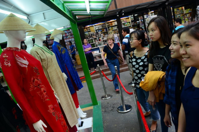 Du khách xem bộ áo dài của nhà thiết kế Trịnh Hoàng Diệu (em gái cố nhạc sĩ Trịnh Công Sơn) được trưng bày tại đường sách Nguyễn Văn Bình, Q.1, TP.HCM chiều 28-3 - Ảnh: Quang Định