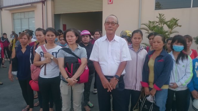 Ông Tango Hirosuke cùng các công nhân của mình đứng trước cổng công ty khi bị đổ đất, rào chắn - Ảnh: Nguyễn Hữu