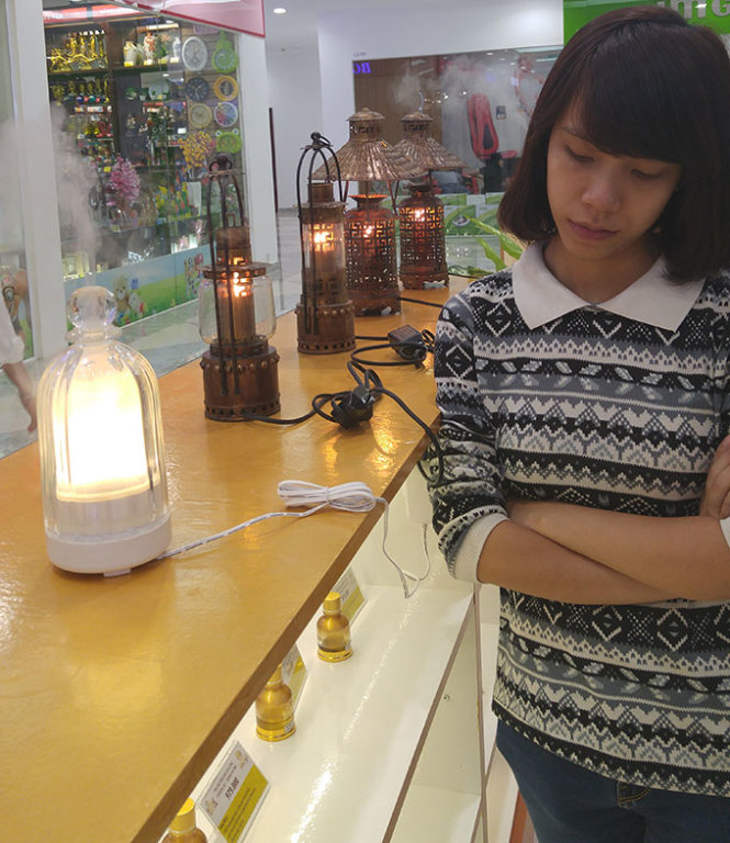 Khách hàng đang lựa chọn tinh dầu và đèn xông tinh dầu ở một cửa hàng trong trung tâm thương mại - Ảnh: Minh Phượng