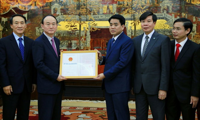 Chủ tịch UBND thành phố Hà Nội trao giấy chứng nhận đăng ký đầu tư dự án “Trung tâm nghiên cứu và phát triển Samsung tại thành phố Hà Nội” cho lãnh đạo Tổ hợp Samsung Việt Nam.