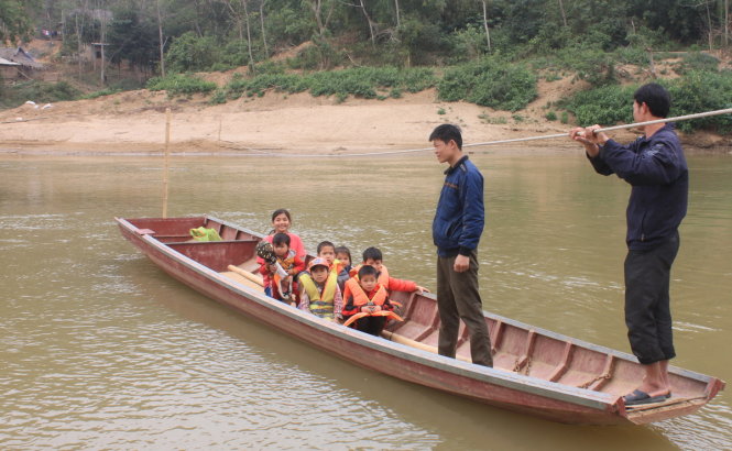 Hàng ngày, người dân và các em học sinh bản Vui, xã Thanh Xuân, huyện Quan Hóa qua sông Mã trên chiếc thuyền mỏng manh - Ảnh: Hà Đồng
