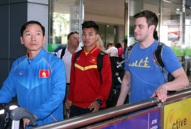 Bác sỹ Đồng Xuân Lâm (bìa trái) và hậu vệ Vũ Văn Thanh (giữa) tại sân bay. Ảnh: N.K