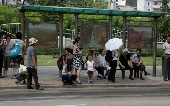Người dân chờ xe buýt tại một trạm xe buýt ở Triều Tiên - Ảnh: AP