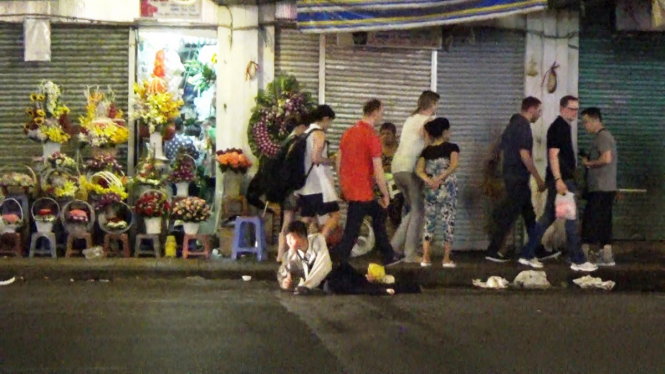 Hiếu giả vờ dị tật lăn lê trên đường phố xin tiền du khách - Ảnh: Thăng Long