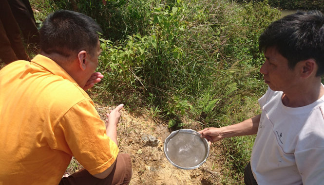 Ông Tường Thế Hà, Phó Tổng giám đốc Công ty TNHH MTV Nhôm Lâm Đồng (trái), “thử” mẫu nước bằng tay và miệng - Ảnh: Gia Bảo