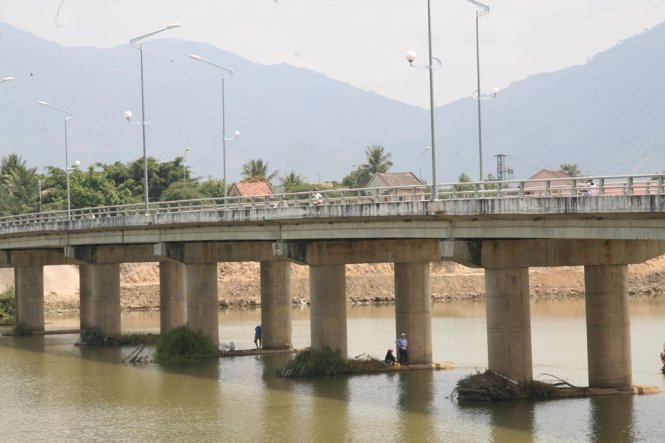 Dưới chân các trụ cầu Thành bắc qua sông Cái tại thôn Phú Lộc Tây, thị trấn Diên Khánh, cỏ cũng mọc xanh, nhiều người ra ngồi được cả ngay giữa dòng sông… - Ảnh: Phan Sông Ngân