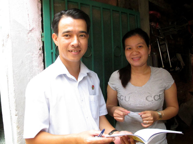 Anh Nguyễn Văn Thủ giao thẻ bảo hiểm cho con của chị Lâm Thị Bích Phượng - Ảnh: K.Anh