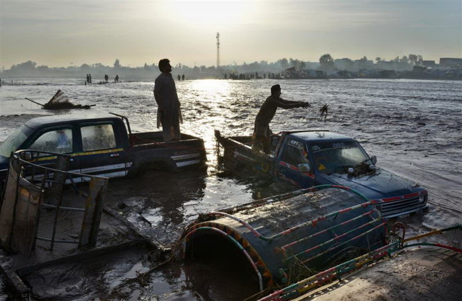 Người dân Pakistan bị kẹt giữa vùng nước ngập - Ảnh: AFP