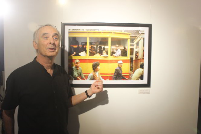 Michel Blanchard vui vẻ giới thiệu bức ảnh chụp xe điện trên phố Hàng Đào nằm 1984 của mình tới với khán giả đến tham dự triển lãm
