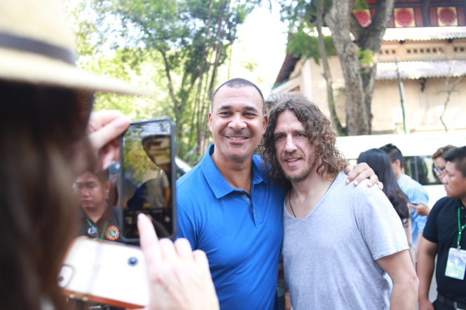 Puyol (phải) và Gullit được một người hâm mộ chụp hình sáng 7-4 - Ảnh: H.A.