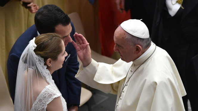 Giáo hoàng Francis chúc phúc cho một đôi vợ chồng mới cưới tại Vatican City hồi tháng 12-2015 - Ảnh: AFP