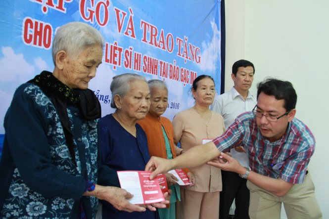 Đại diện báo Tuổi Trẻ trao quà của bạn đọc tặng các gia đình liệt sĩ Gạc Ma ở Đà Nẵng - Ảnh: Hữu Khá
