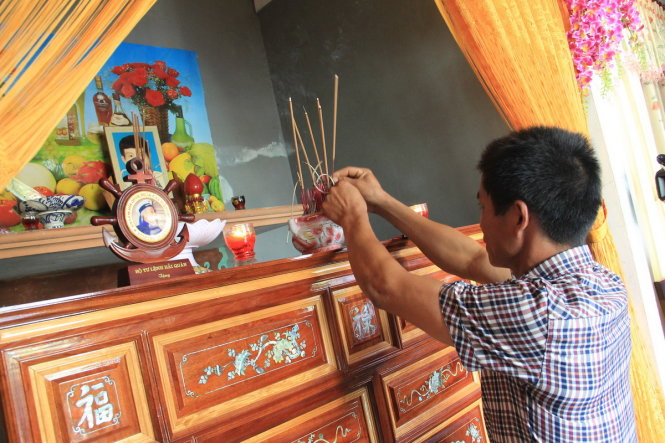 Các thân nhân liệt sĩ thắp hương lên bàn thờ của liệt sĩ Nguyễn Mậu Phong trong lễ trao - Ảnh: Trường Trung
