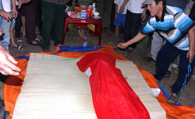 Người dân phường Nghi Hải, TX Cửa Lò làm thủ tục chôn cất xác con cá voi được phát hiện vào chiều 8-4 - Ảnh: Khánh Thành