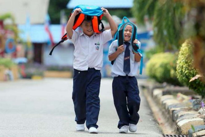 Học sinh Malaysia đi học dưới trời nắng - Ảnh: NSTP