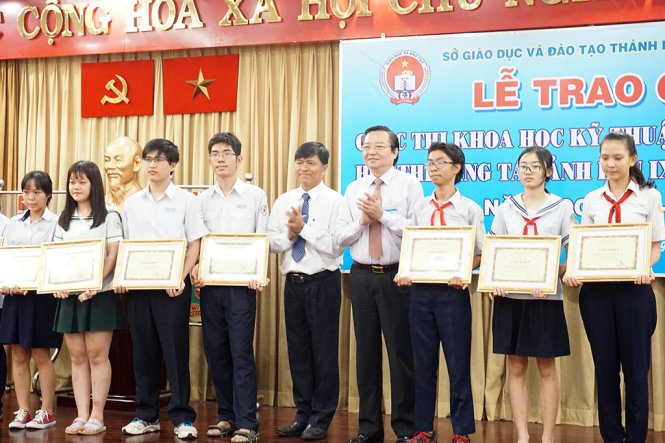 Ông Lê Hồng Sơn (Giám đốc Sở GD-ĐT TPHCM) và ông Nguyễn Văn Hiếu (phó giám đốc Sở GD-ĐT TPHCM) chúc mừng các học sinh đoạt giải - Ảnh; Mỹ Dung