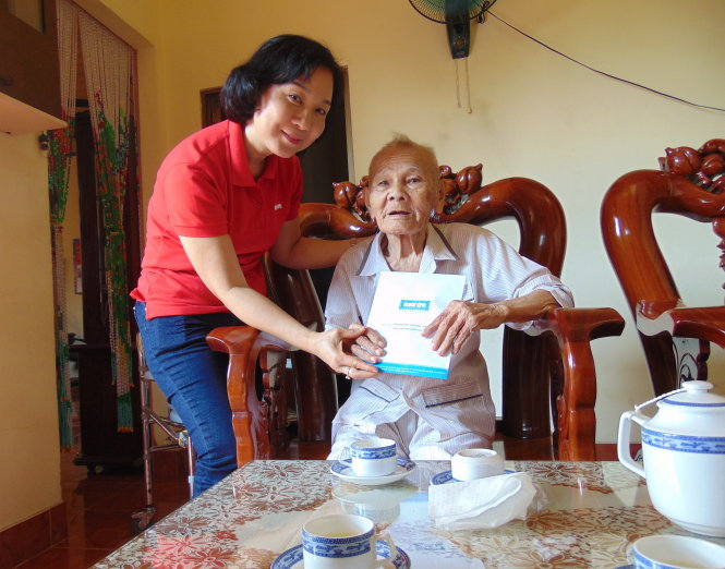 Ông Nguyễn Văn Mưu, cha liệt sĩ Nguyễn Văn Thành, nhận quà tặng của bạn đọc báo Tuổi Trẻ - Ảnh: Ngọc Loan