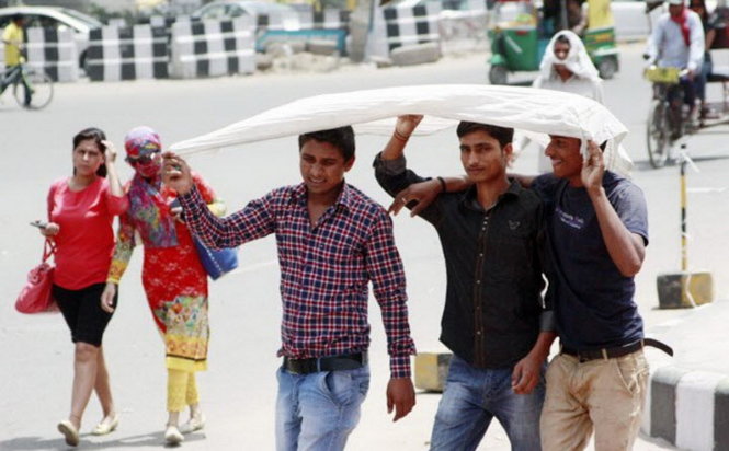Người dân Ấn Độ đi dưới nắng nóng - Ảnh: PTI