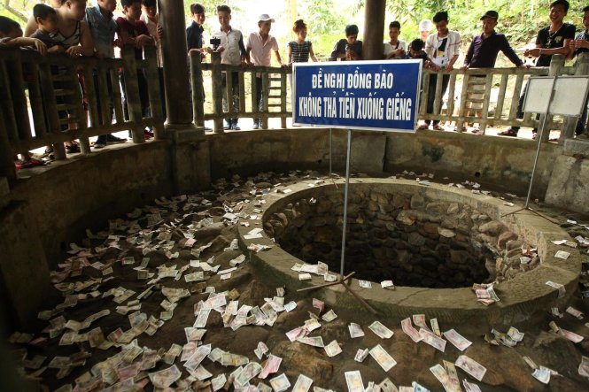 Mặc dù đã có thông báo không thả tiền xuống giếng, nhưng tiền lẻ vẫn được ném la liệt tại khu vực Giếng Ngọc - Ảnh: Nguyễn Khánh