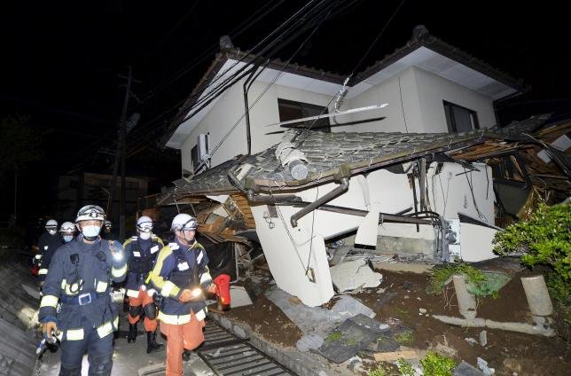 Lính cứu hỏa Nhật Bản kiểm tra một ngôi nhà bị sập sau trận động đất. Ảnh: Reuters