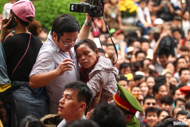 Một người phụ nữ ngất xỉu khi bị đám đông chèn ép sau khi rào chắn được dỡ bỏ - Ảnh: Nguyễn Khánh