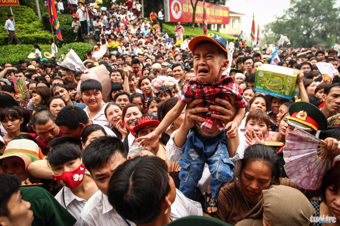 Một cậu bé oà khóc và được gia đình đưa vào khu vực cách ly với đám đông - Ảnh: Nguyễn Khánh