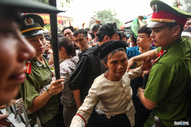 Một phụ nữ lớn tuổi được nhân viên đặc cách vượt qua cổng rào chắn dưới chân đền Hùng để đảm bảo an toàn - Ảnh: Nguyễn Khánh
