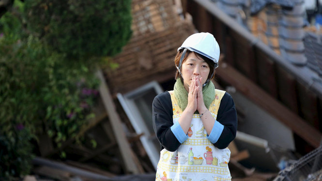 Người phụ nữ Nhật thẫn thờ trước khung cảnh đổ nát do động đất gây ra ở thị trấn Mashiki, phía nam Nhật Bản. Ảnh: Reuters