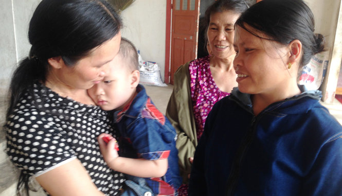 Cô Tuyết ân cần hỏi thăm sức khỏe bé Nguyễn Văn Quyết, 2 tuổi bị ong đốt - Ảnh: Doãn Hòa