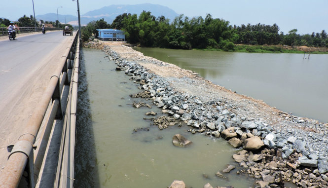 Sông Cái Nha Trang không còn đủ nước tràn qua đập ngăn này tại cầu Vĩnh Phương. Ngay phía hạ lưu con đập nước sông đã bị nhiễm mặn gần ngang nước biển - Ảnh: Phan Sông Ngân