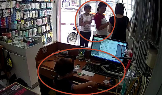 Hai phụ nữ dàn cảnh để cậu bé lẻn vào trong trộm iPhone - Ảnh cắt từ clip