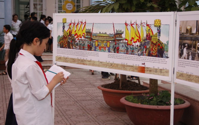 Học sinh trường tiểu học Bạch Mai tranh thủ ghi chép tư liệu từ bộ sách Lịch sử Việt Nam bằng tranh - Ảnh: Đức Triết